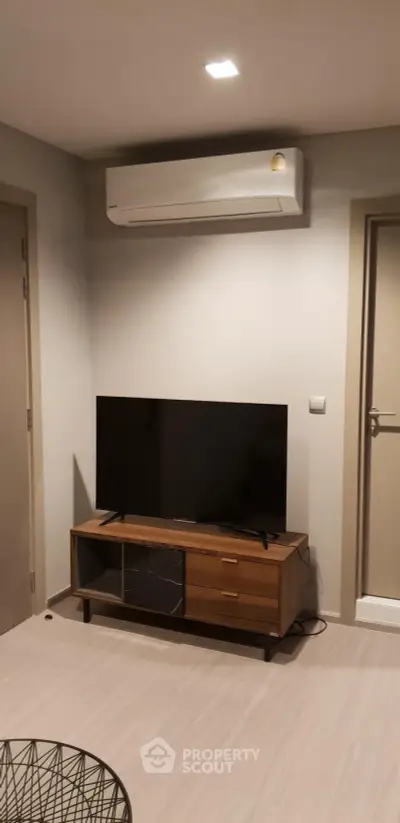 Modern living room with sleek TV stand and air conditioning unit, perfect for cozy entertainment.