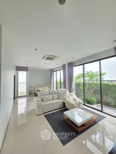 Spacious modern living room with large windows and garden view
