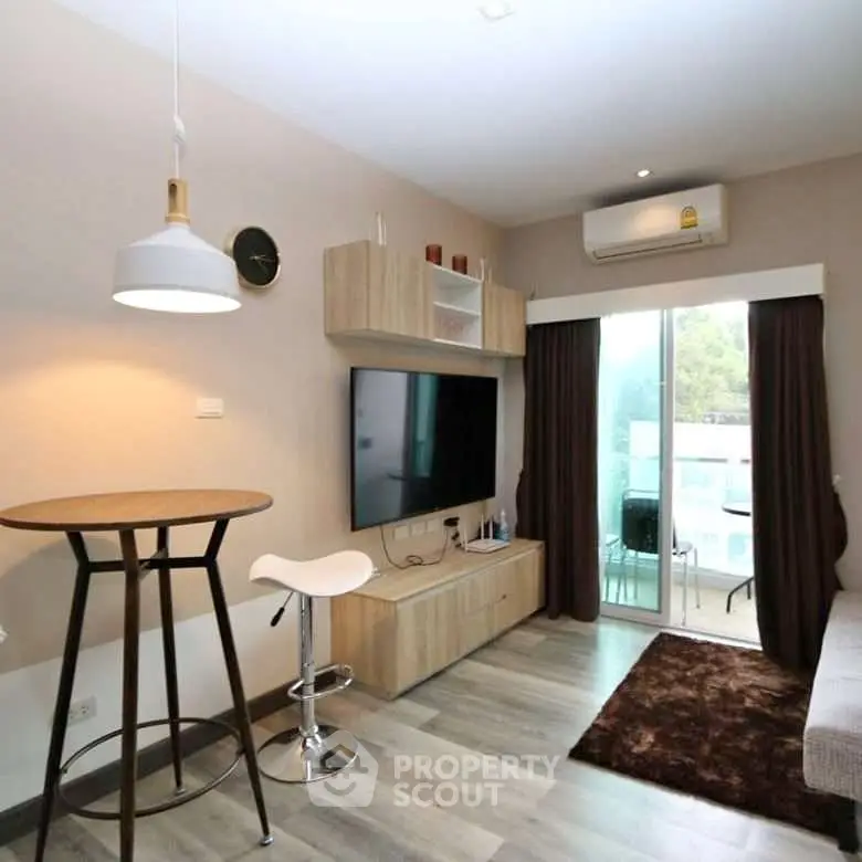 Modern living room with stylish decor and balcony view in a cozy apartment.
