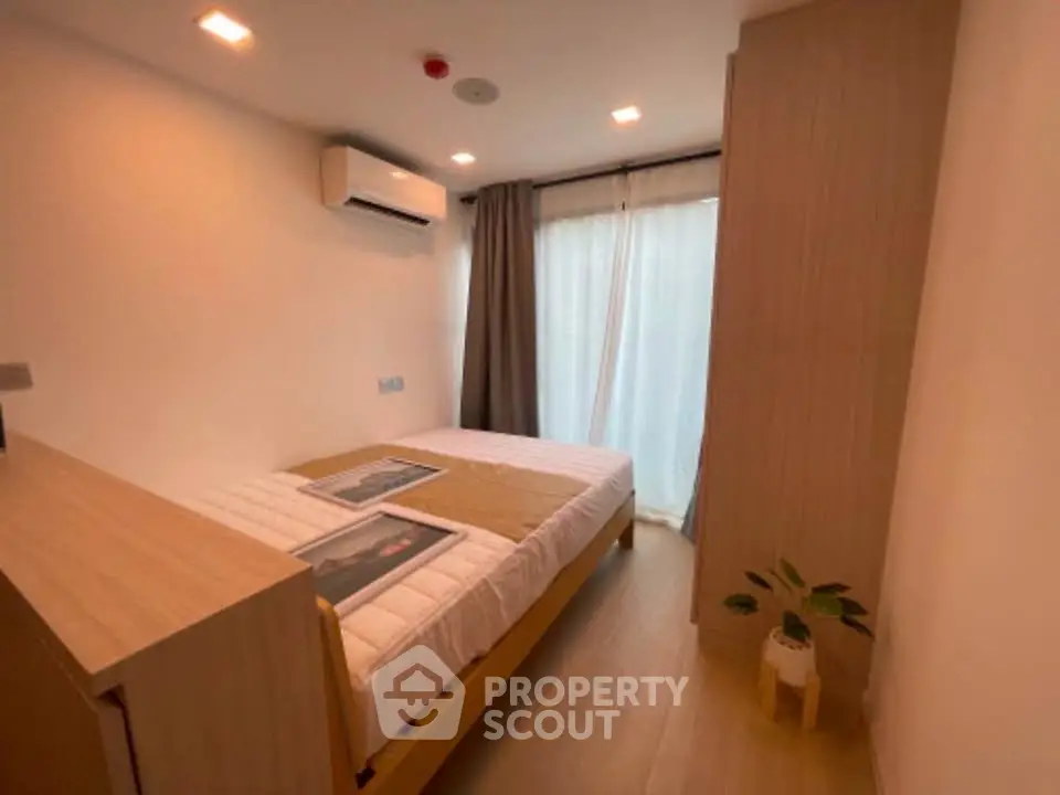 Cozy bedroom with modern decor and natural light in a stylish apartment.
