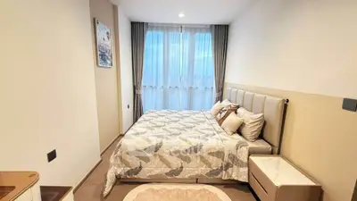 Cozy bedroom with elegant decor and large window offering natural light.