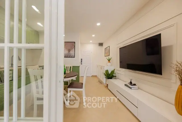 Modern living room with stylish decor and large TV, perfect for relaxation and entertainment.