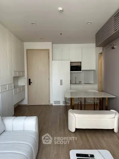 Modern living room with sleek furniture and compact kitchen in open layout