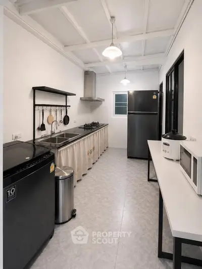 Modern kitchen with sleek appliances and open layout, featuring a gas stove and ample counter space.