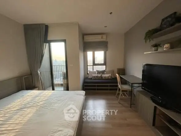 Modern bedroom with balcony access and stylish decor in a high-rise apartment.