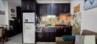 Charming kitchen with dark cabinets and marble backsplash in cozy apartment.