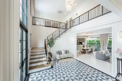 Luxurious open-plan living room with elegant staircase and modern decor