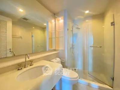 Modern bathroom with glass shower and elegant fixtures in a bright, spacious setting.