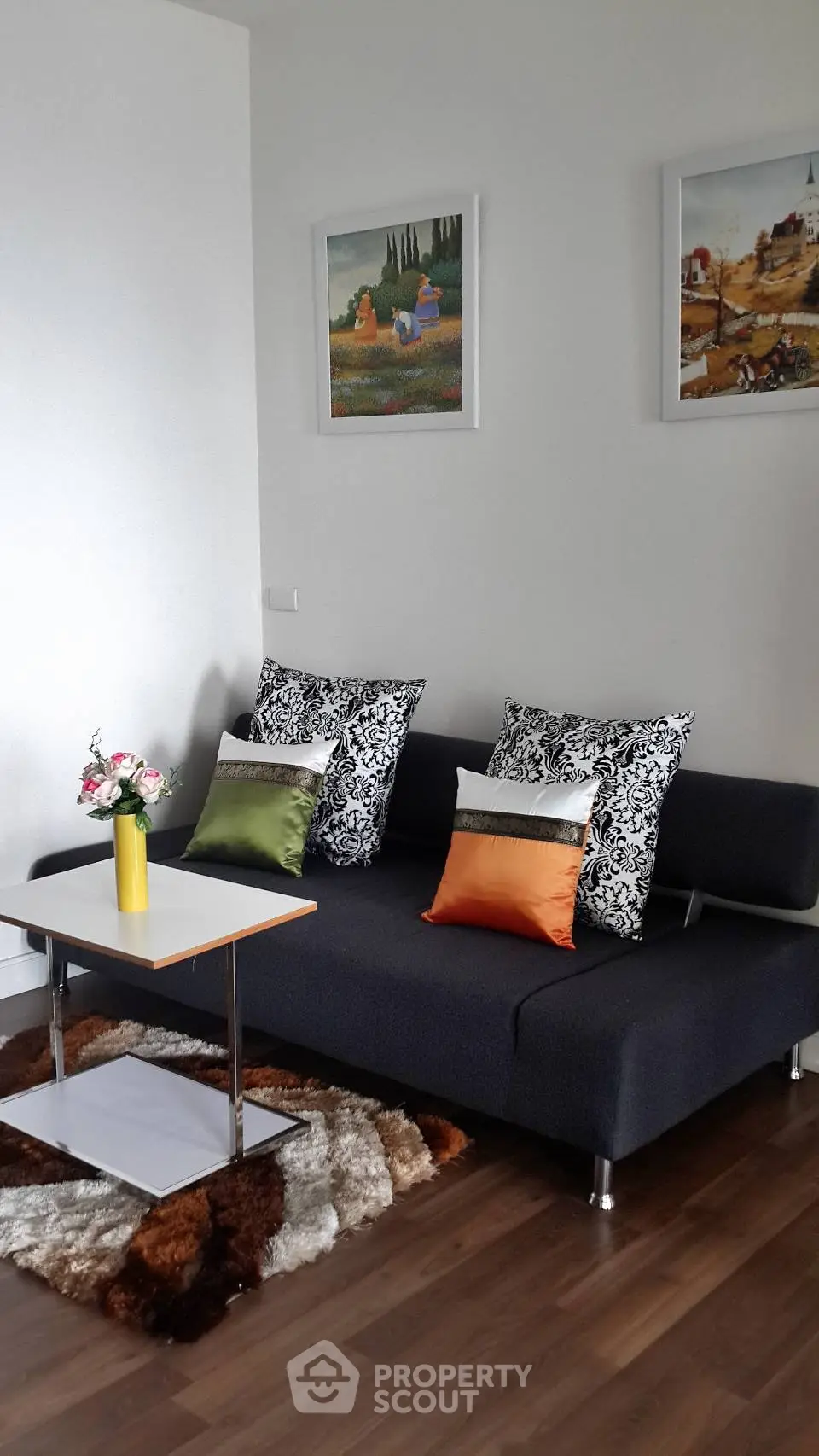 Chic living room with modern sofa, vibrant cushions, and stylish decor for a cozy ambiance.