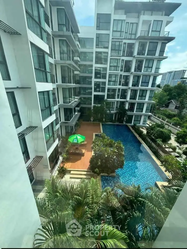 Modern apartment complex with pool view and lush greenery, perfect for urban living.