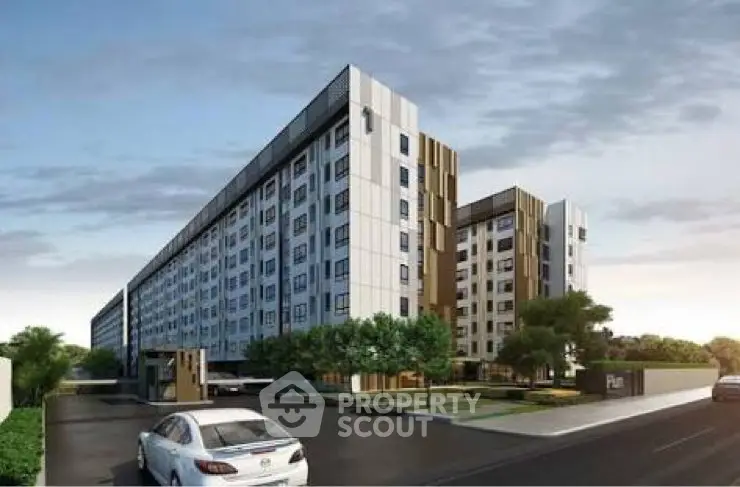 Modern apartment building exterior with landscaped entrance and parking area.