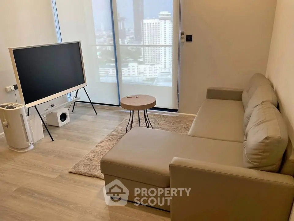 Modern living room with sleek furniture and city view, featuring a stylish TV setup and cozy seating area.