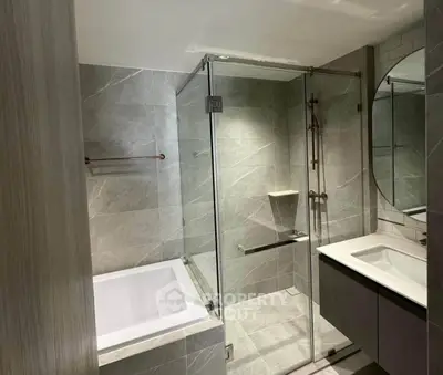 Modern bathroom with glass shower and bathtub in luxury apartment