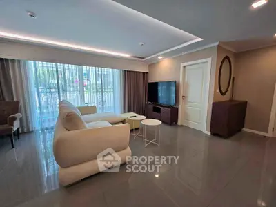 Spacious modern living room with elegant furniture and large windows offering natural light.