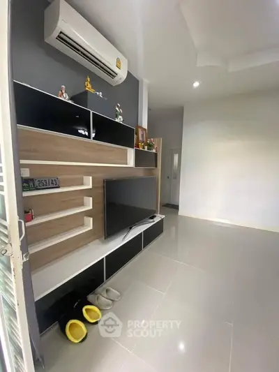 Modern living room with sleek TV unit and air conditioning, perfect for cozy relaxation.