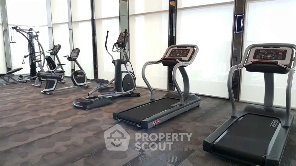 Modern gym with state-of-the-art fitness equipment in luxury residential building.