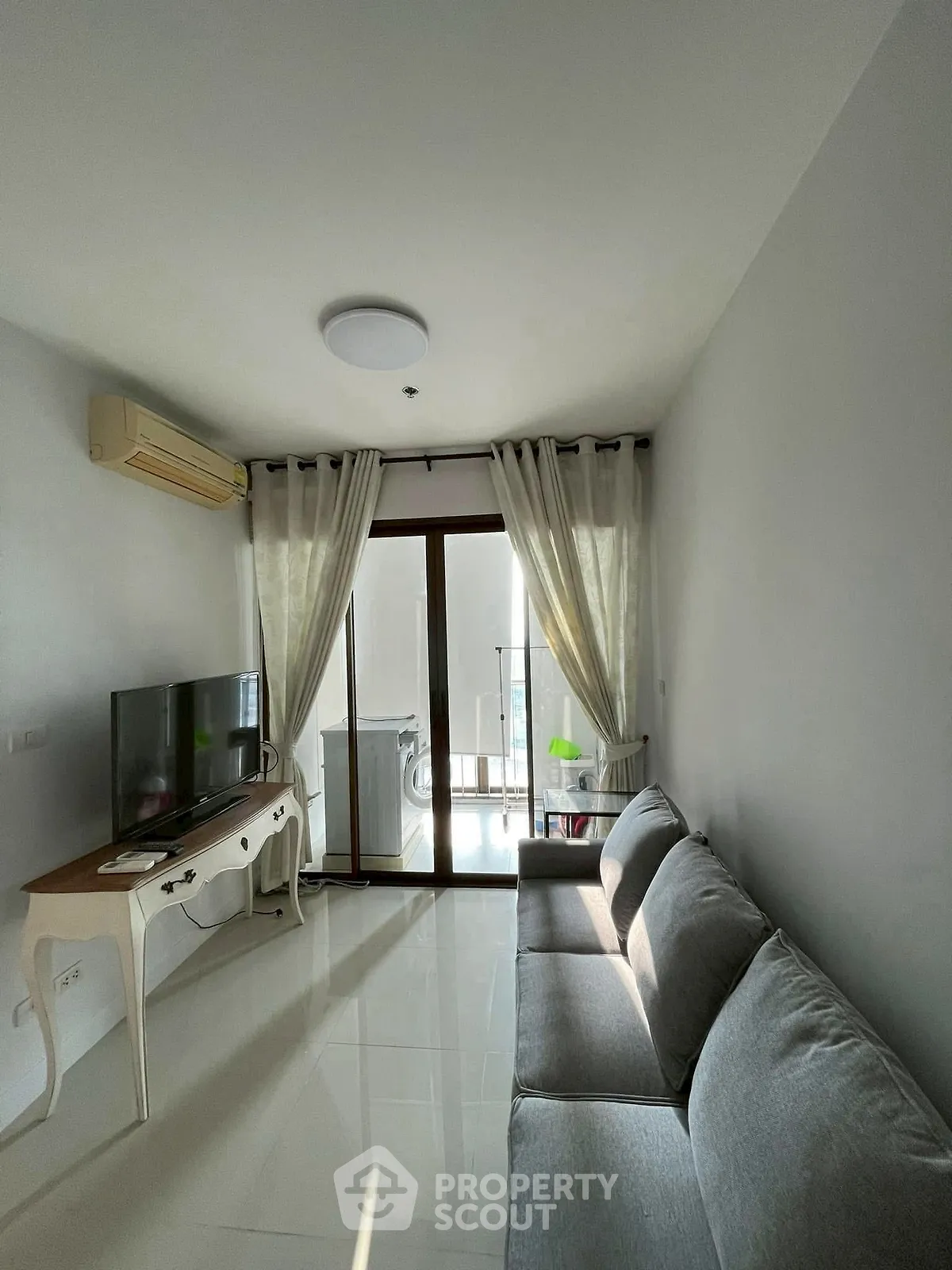 Bright living room with modern furniture and balcony access, perfect for relaxation and entertainment.