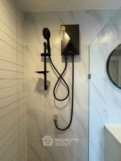 Modern bathroom with sleek black shower fixture and elegant tile design.