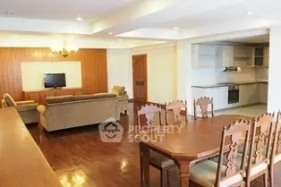 Spacious open-layout living and dining area with elegant wooden furniture and modern kitchen.