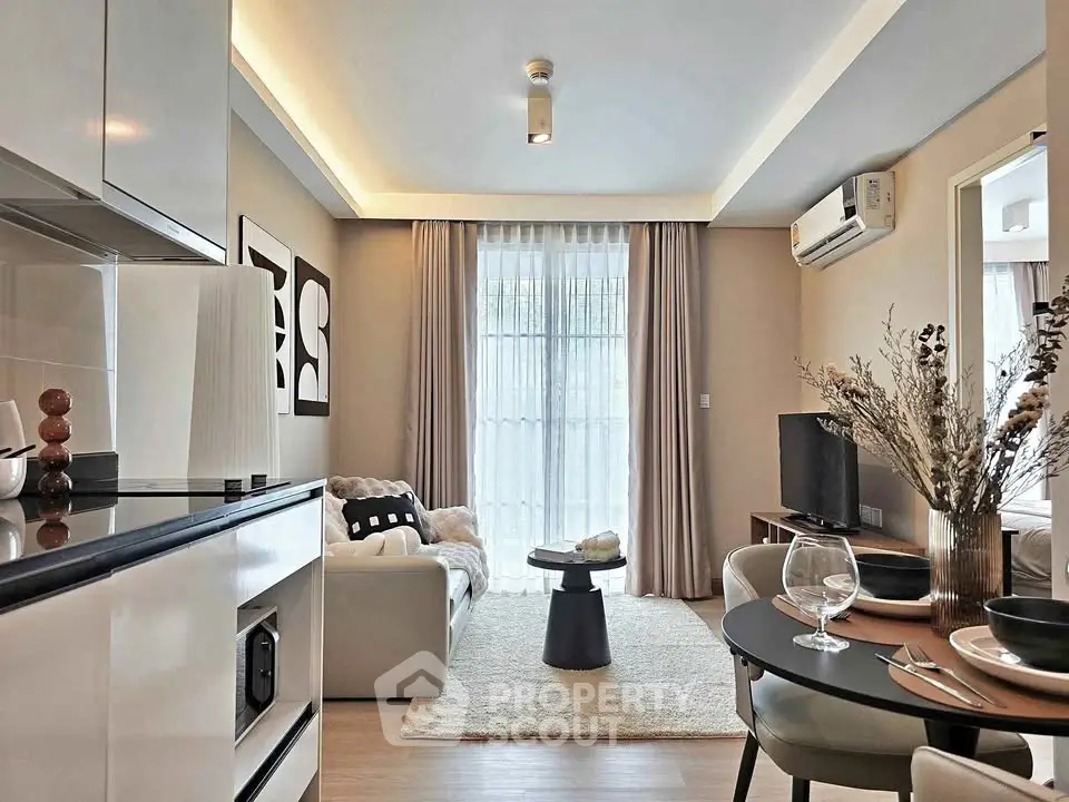 Modern living room with stylish decor and open kitchen layout, featuring cozy seating and elegant dining area.