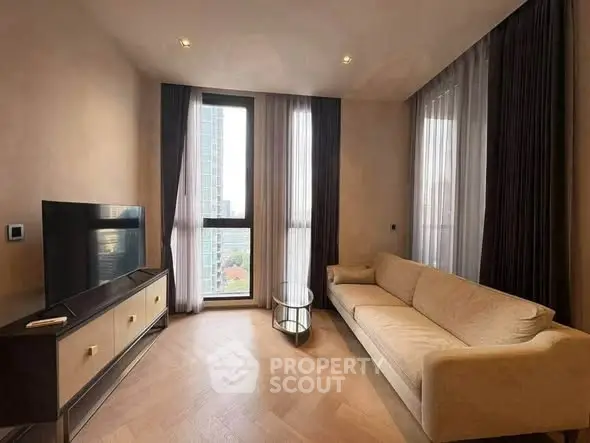 Modern living room with elegant decor and city view, featuring a cozy sofa and large TV.