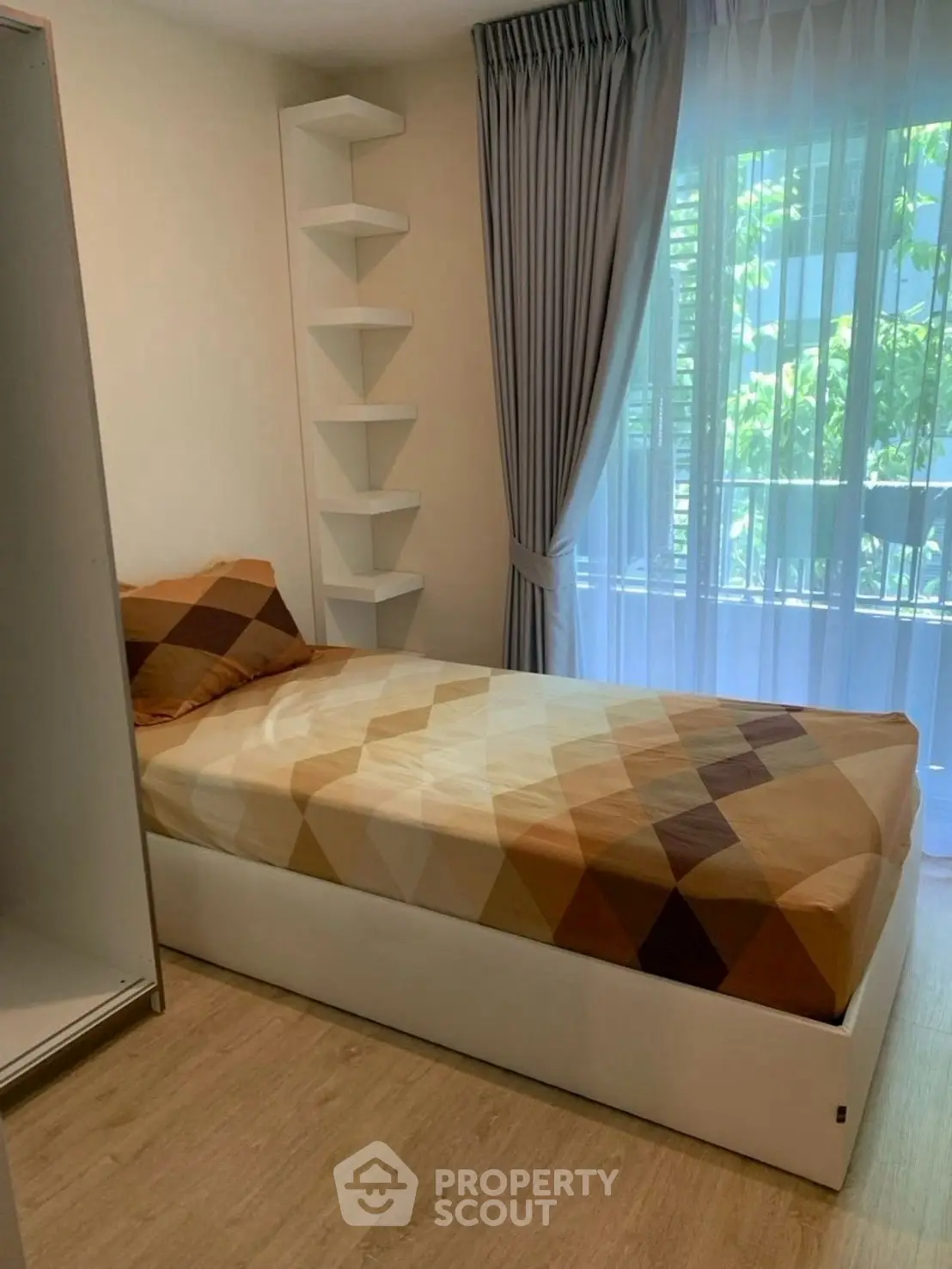 Cozy bedroom with single bed and modern decor, featuring floor-to-ceiling window and elegant curtains.