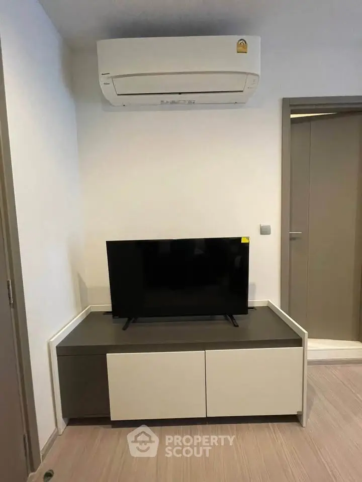 Modern living room with sleek TV stand and air conditioning unit, perfect for cozy entertainment.
