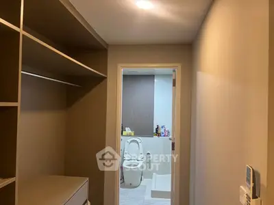 Modern bathroom with open closet space and sleek design, perfect for contemporary living.