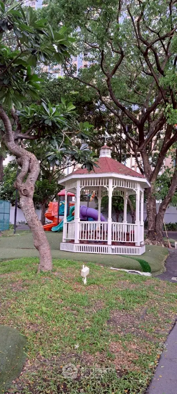 Charming garden gazebo surrounded by lush greenery in a serene residential area.
