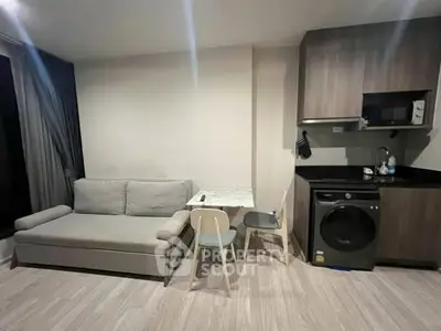 Modern living room with compact kitchen and washing machine, ideal for urban living.