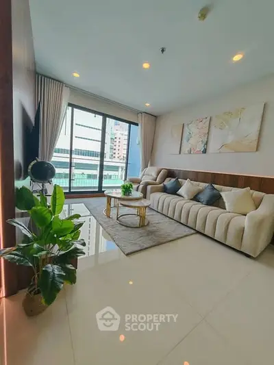 Luxurious living room with modern decor and large windows offering city views.