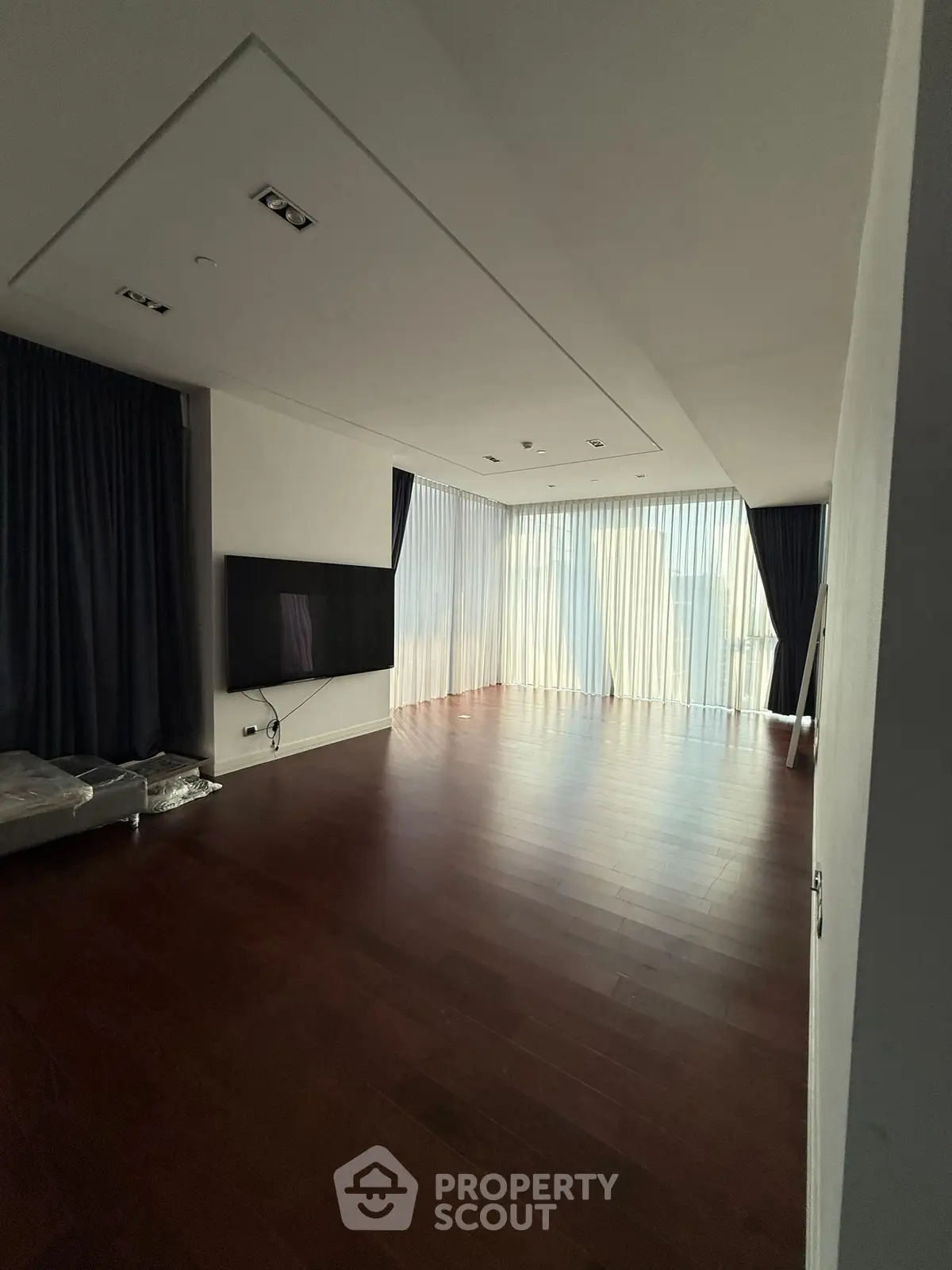 Spacious modern living room with hardwood floors and large windows