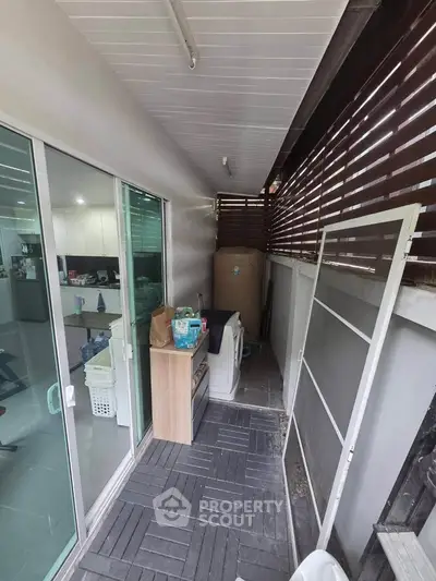 Charming balcony with sliding glass doors and modern outdoor storage solutions.