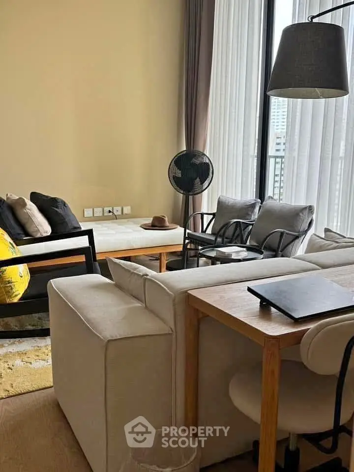 Modern living room with stylish furniture and large windows offering natural light.