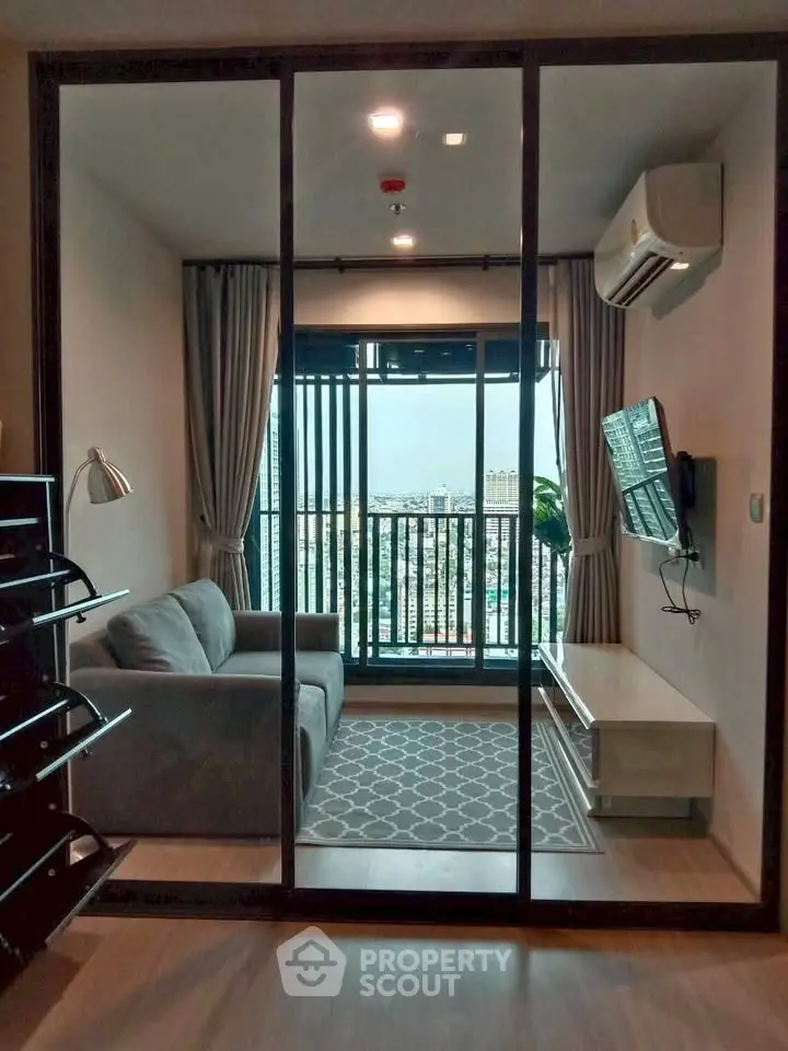 Modern living room with balcony view, featuring sleek furniture and air conditioning.