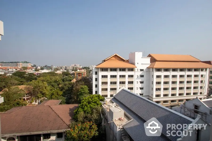 Stunning cityscape view from high-rise building showcasing urban living and lush greenery.