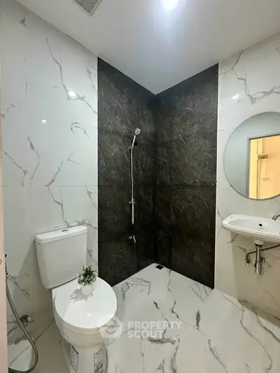 Modern bathroom with marble tiles and sleek fixtures in a stylish apartment.