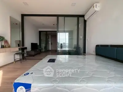 Spacious modern bedroom with sliding glass doors and air conditioning, featuring a luxurious mattress.