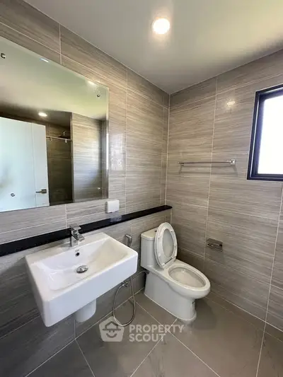 Modern bathroom with sleek fixtures and large mirror in contemporary home