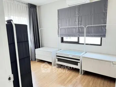 Spacious bedroom with modern furnishings and large windows for natural light.