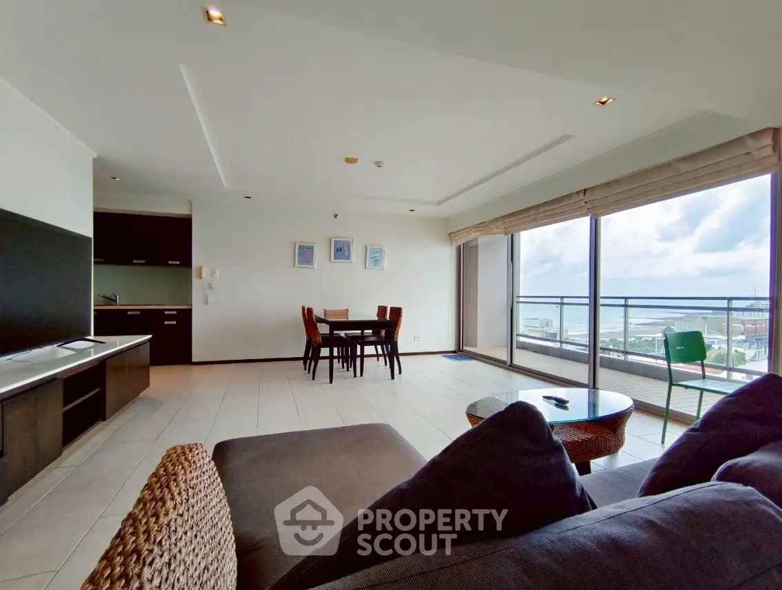 Spacious living room with ocean view and modern furnishings in luxury apartment.