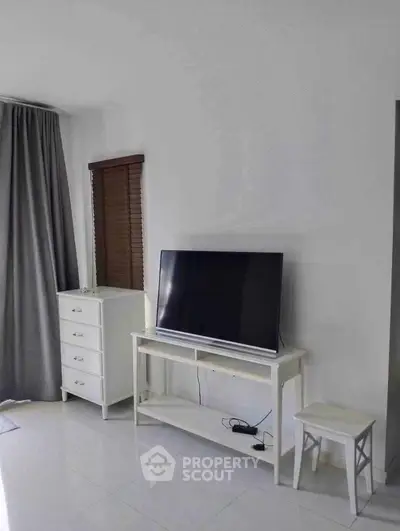 Modern living room with sleek TV stand and elegant curtains, perfect for cozy entertainment.