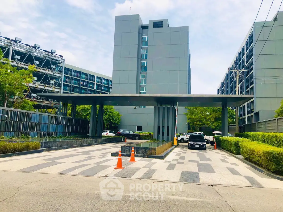 Modern building entrance with sleek design and ample parking space