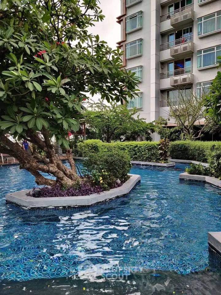 Luxurious residential building with serene pool and lush greenery, perfect for relaxation and leisure.