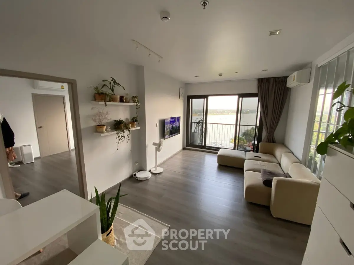 Spacious modern living room with large windows and balcony view