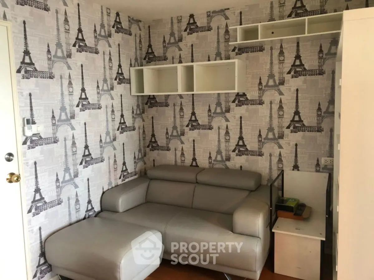 Chic living room with Eiffel Tower wallpaper and modern gray sofa.