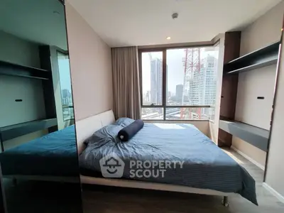 Modern bedroom with city view and sleek furnishings in high-rise apartment.