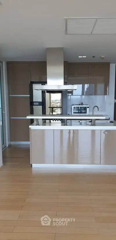 Modern kitchen with sleek cabinetry and island in upscale apartment