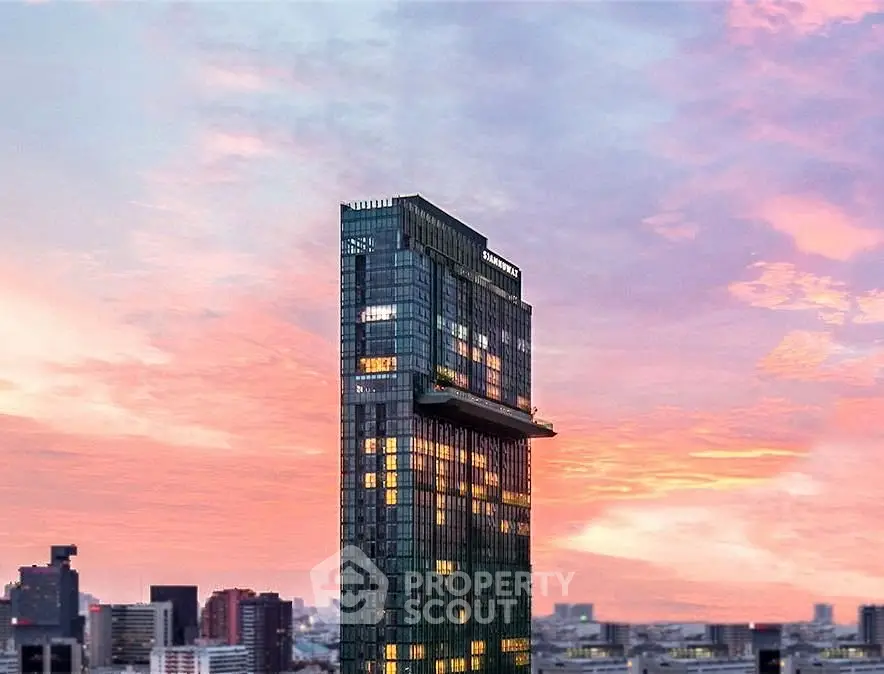 Stunning skyscraper with modern architecture against a vibrant sunset skyline.