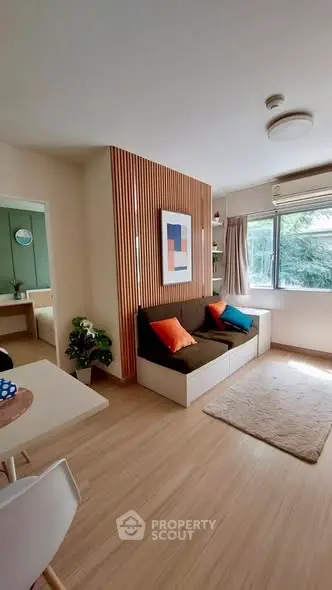 Cozy living room with modern decor and natural light in a stylish apartment.